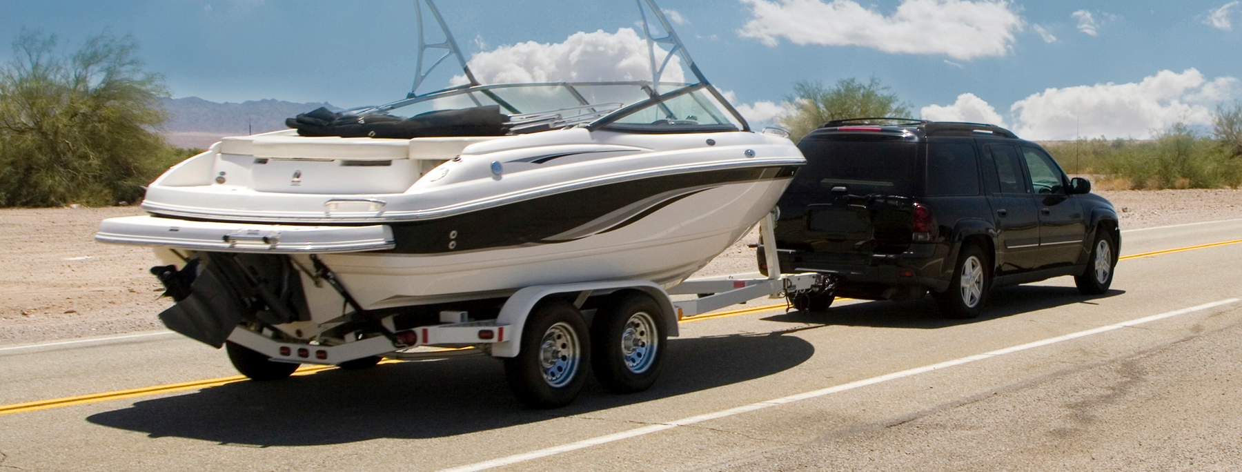 black SUV towing a boat