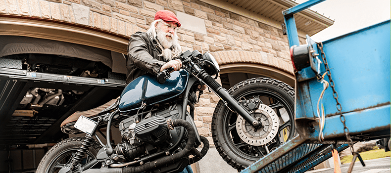 older man loading a bike onto a trailer for transport